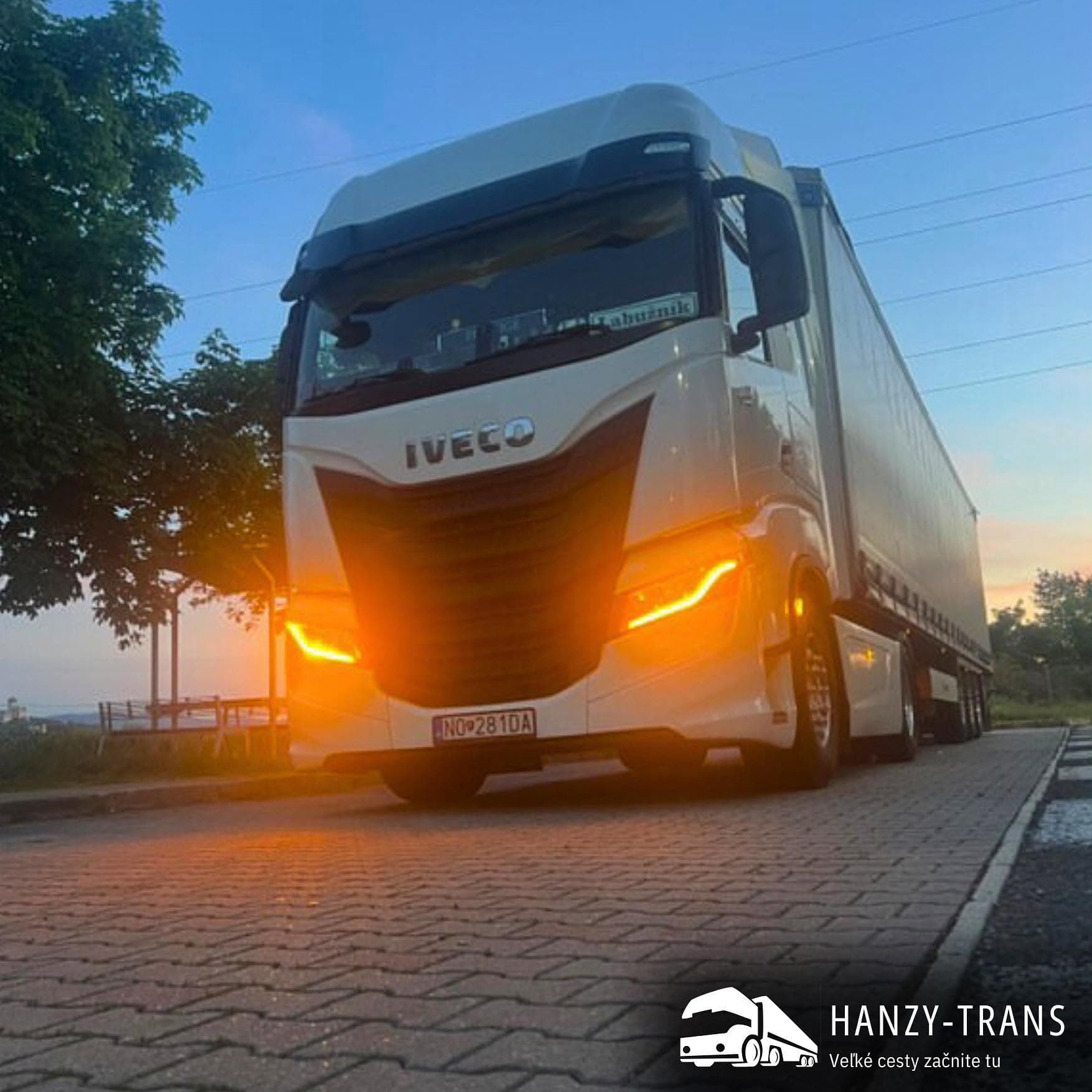 Ilustračný záber bieleho kamióna IVECO s rozsvietenými svetlami.